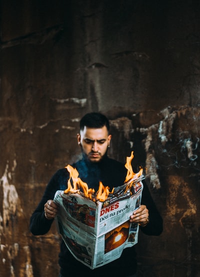 男子手持燃烧的报纸